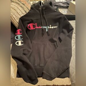 Champion black hooded sweatshirt with pink, blue, and white colored writing